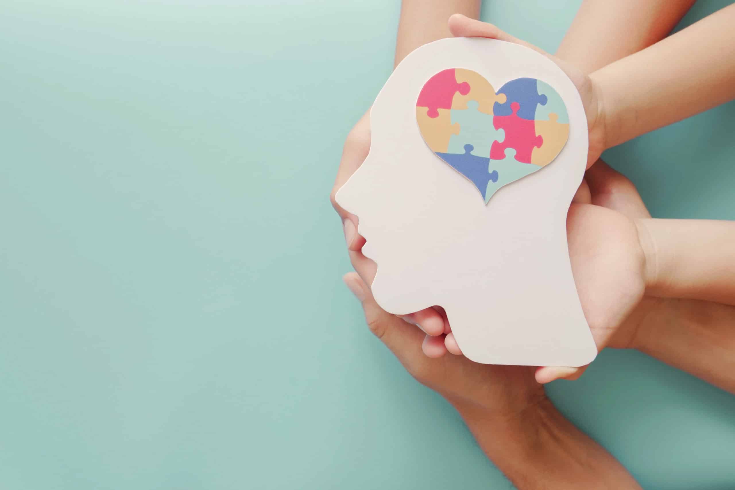 Adult and chiildren hands holding head with jigsaw puzzle heart shape, Autism awareness,Autism spectrum disorder family support concept, World Autism Awareness Day